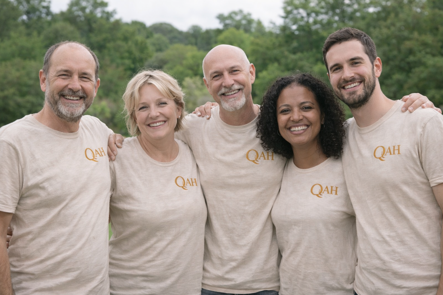 Five QuAH Academy members wearing matching beige t-shirts with 'QuAH' logo outdoors.